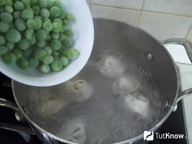 Groene erwten toegevoegd aan de pan