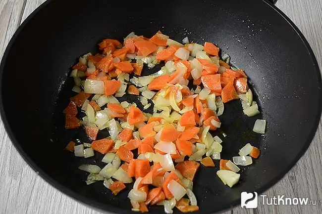 Carrots and onions are fried in a pan