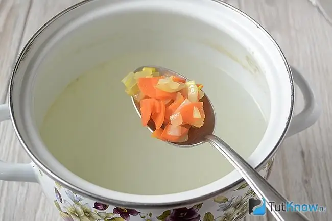 Adding carrots with onions to the soup