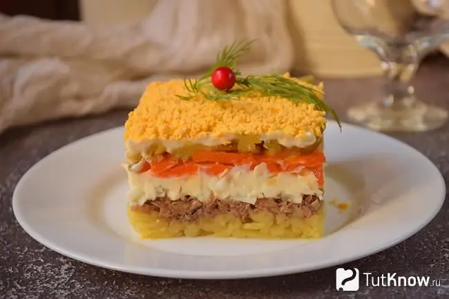 Layered salad with sprats on the festive table