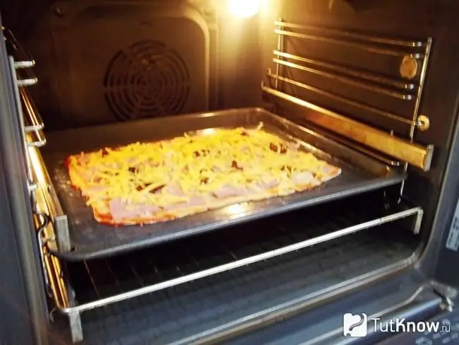 Ang pizza ay sinablig ng keso at ipinadala sa oven