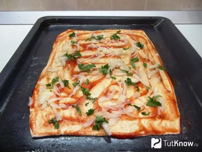 The dough is lined with greens and onions