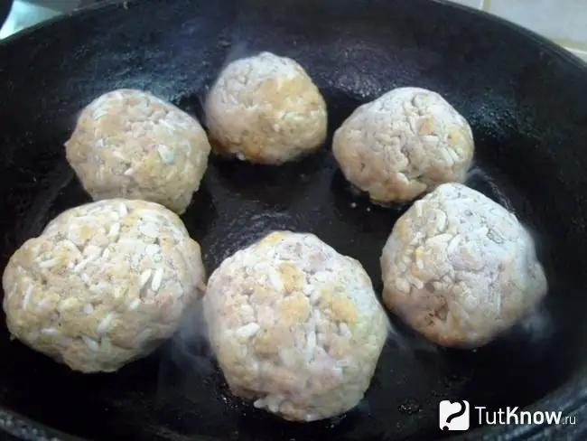 Meatballs are laid out in a frying pan