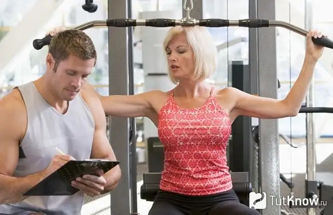 Een fitnesstrainer werkt met haar afdeling