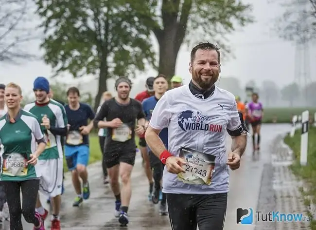 Les jeunes qui courent sous la pluie sur la route