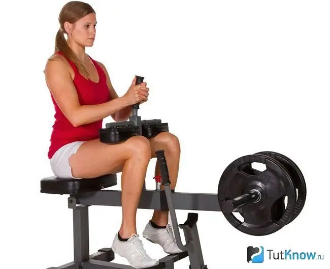 Gadis yang duduk di simulator Seated Calf Raise