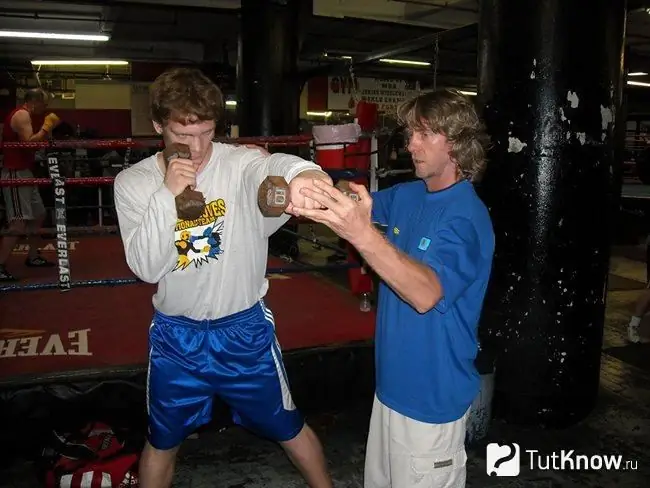 Un jeune athlète effectue une boxe fantôme avec des poids supplémentaires