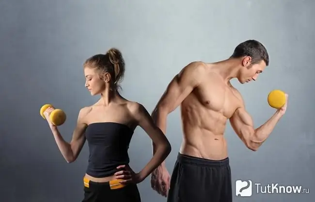 The guy and the girl are holding dumbbells in their hand