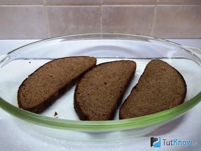 Das Brot wird in Scheiben geschnitten und auf einem Backblech ausgelegt