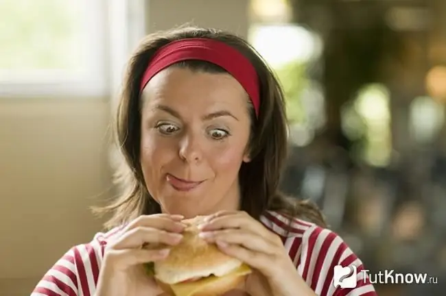 Chica mira con impaciencia la comida rápida