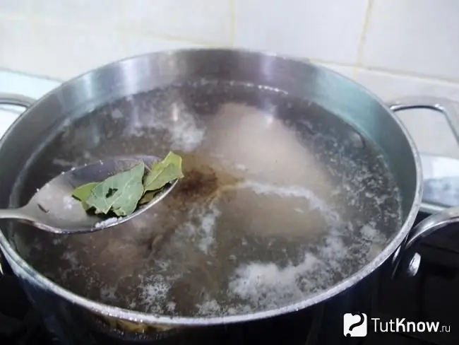 Menambahkan daun salam dan kacang polong allspice ke dalam wajan