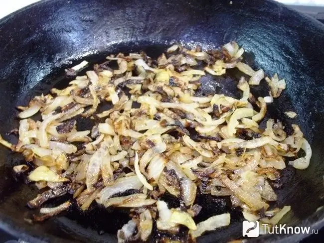 As cebolas são fritas em uma frigideira no azeite até dourar