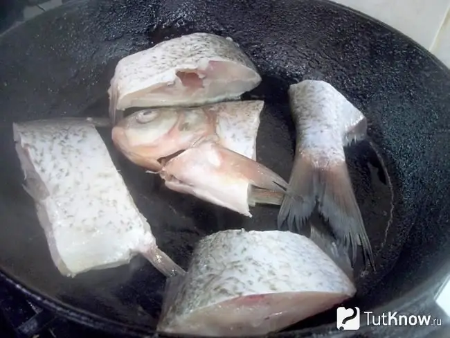 El pescado está en una sartén de aceite caliente