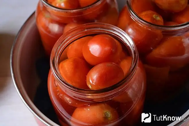 Frascos de tomates en una olla con agua