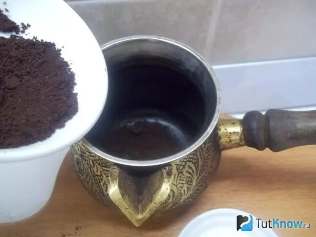 Kaffee wird in einen Türken gegossen