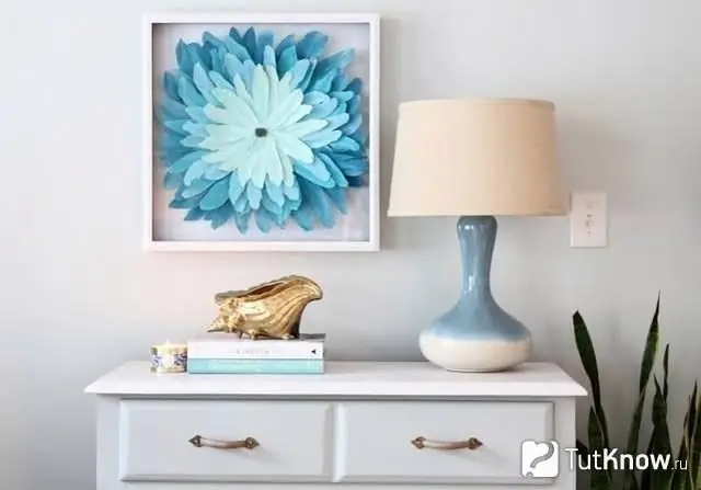 Cuadro con una flor de pluma colgada en la pared