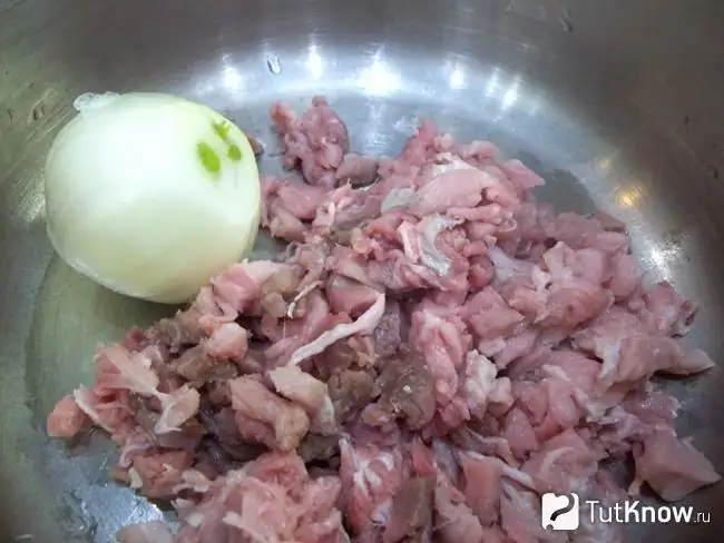 Sliced meat with onion stacked in a saucepan