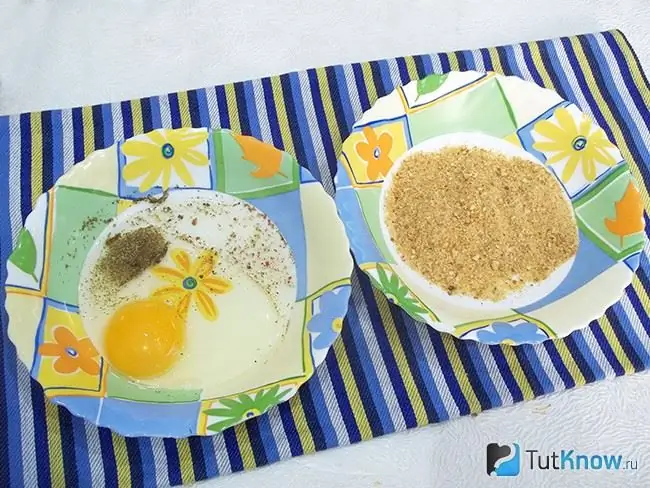 En un plato, se combina un huevo con especias y se vierten galletas saladas en el otro