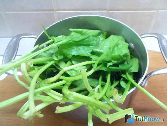 Spinach is folded into a saucepan