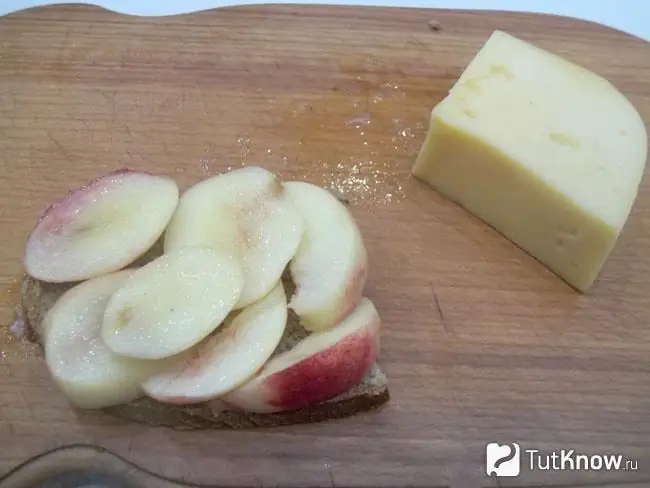 Sliced peaches are laid out on top of the bread