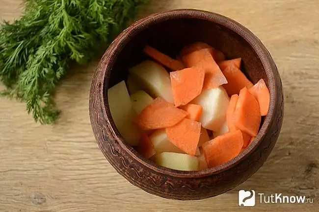 Patatas en rodajas con zanahorias en una olla