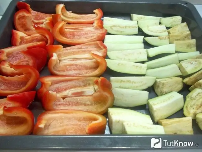 Les aubergines et les poivrons hachés sont disposés sur une plaque à pâtisserie