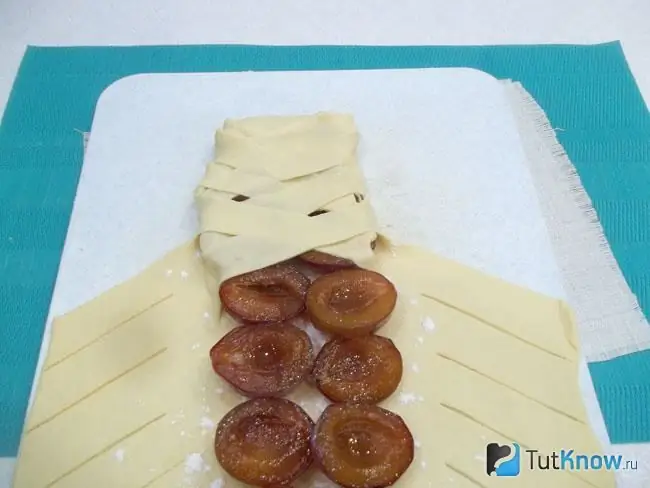 The free edges of the dough are cut into strips and a pigtail roll is formed