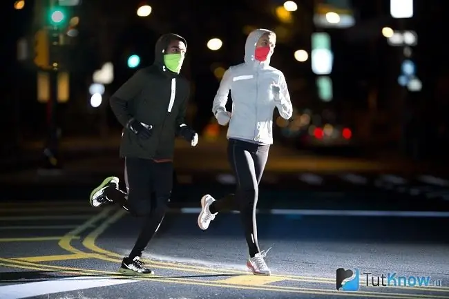 Mann und Frau joggen im Winter am Abend