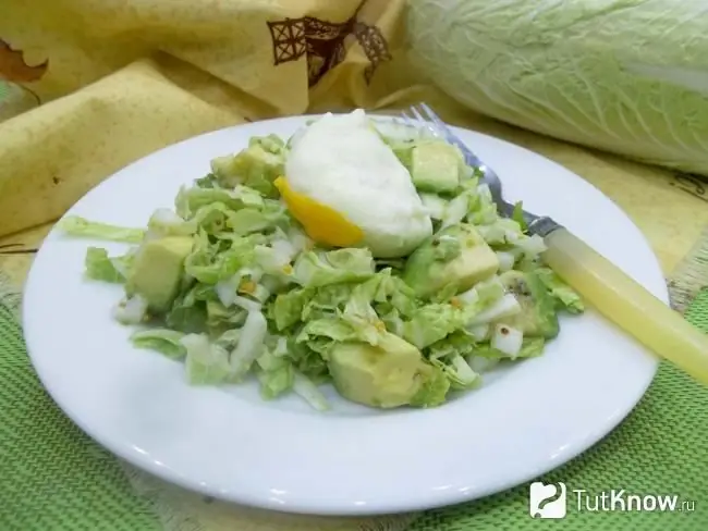 Ensalada de col china preparada, aguacate y huevos escalfados