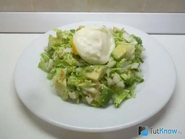 Ensalada de col china preparada, aguacate y huevos escalfados