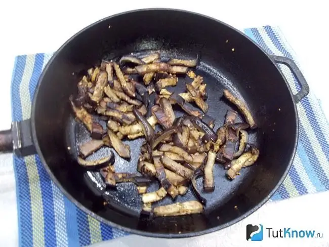 Aubergines worden gesneden en gebakken in een pan