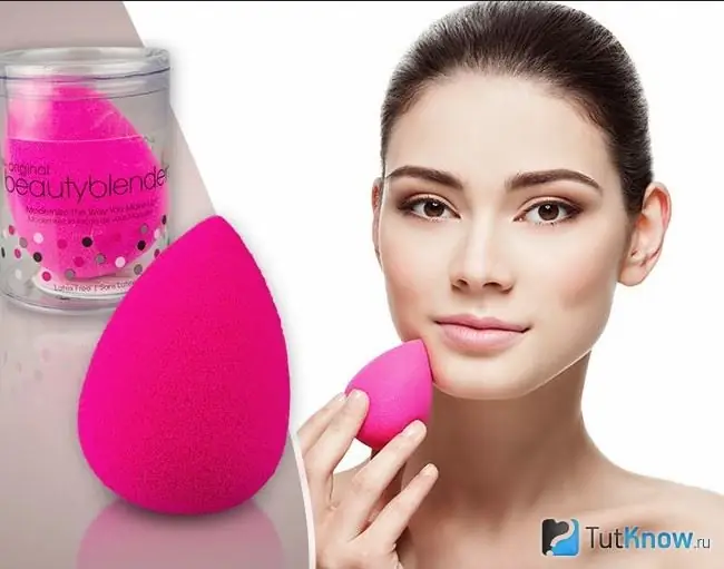 Djevojka drži beauty blender blizu lica