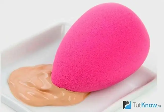 Beauty blender lângă fond de ten