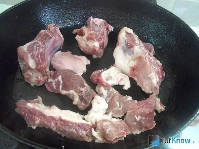 The meat is cut into pieces and fried in a pan